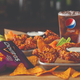 Wings next to purple Doritos bag and glass of Pepsi